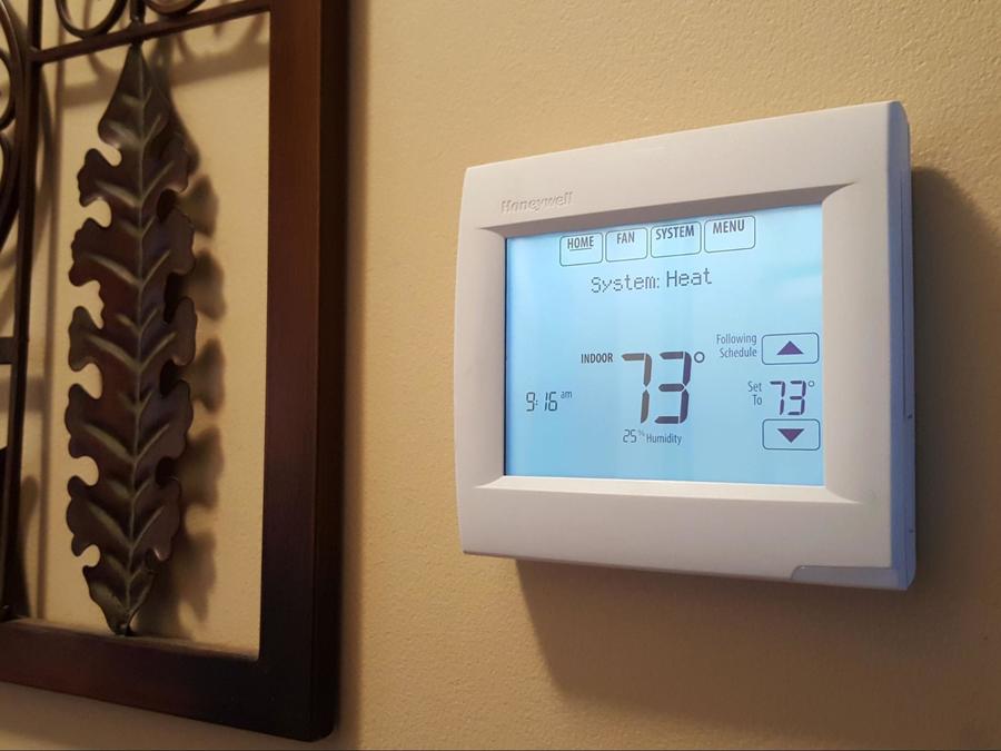 Programmable thermostat with 73 degrees Fahrenheit on the display and on HEAT mode
